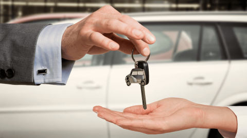 person handing keys to new car